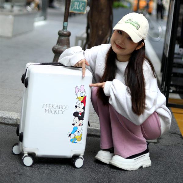 Person showcasing white Mickey and Friends suitcase, highlighting playful design for wholesale