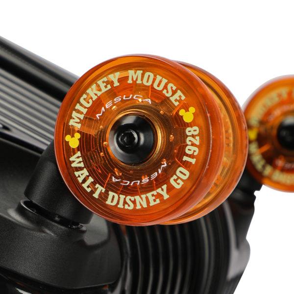 Close - up of orange MICKEY suitcase wheel with branding, showcasing Disney IP licensing for partnerships