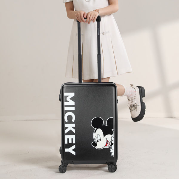 Model with 20 - inch black Mickey suitcase, showcasing travel - ready style for wholesale & Disney IP licensing