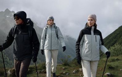 Three People in MESUCA Hiking Gear Trekking Through a Misty, Mountainous Landscape with “MEGOS by MESUCA” Branding